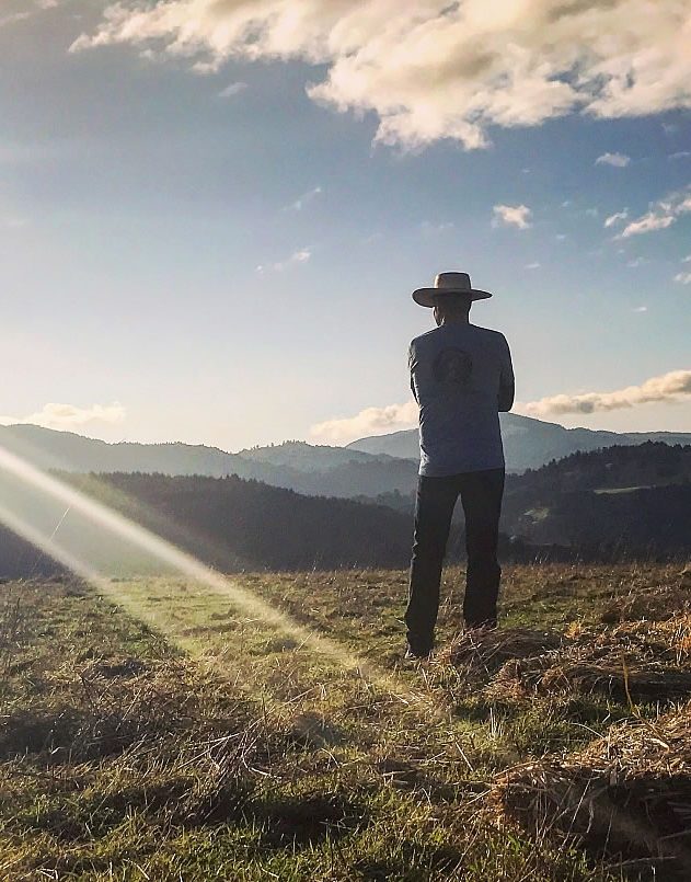 man in hat looking out on open land